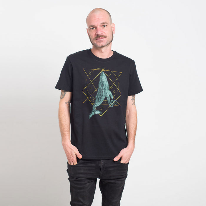 Camiseta negra con ilustración de ballena con bicicleta en tonos azules junto con una geometría decorativa en amarillos.
