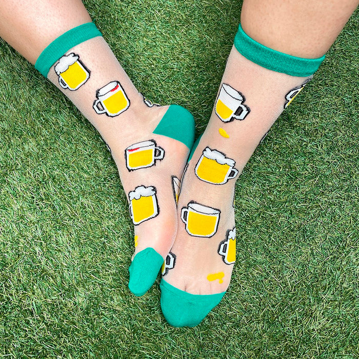 Calcetines de malla transparentes con dibujos de cervezas. Calcetines con estampado de jarras de cerveza con el remate, el talón y la punta en verde.