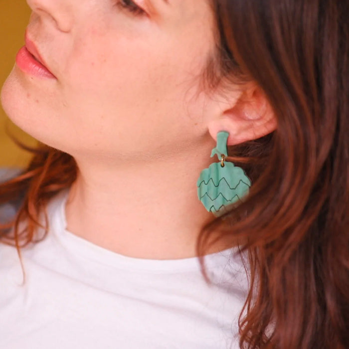 Modelo con Pendientes de metacrilato en forma de alcachofa.