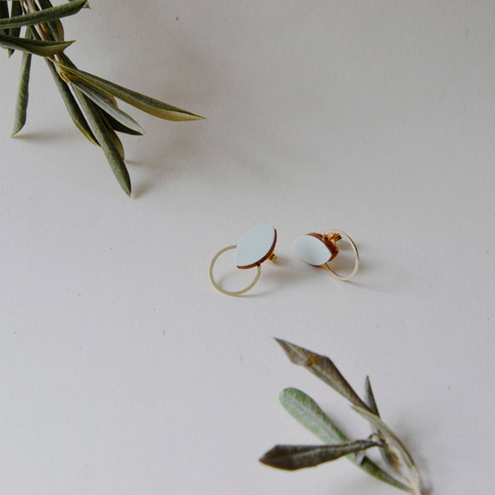 Pendientes de madera con forma de hoja de olivo en color grisc claro y aro plano dorado en la parte inferior.