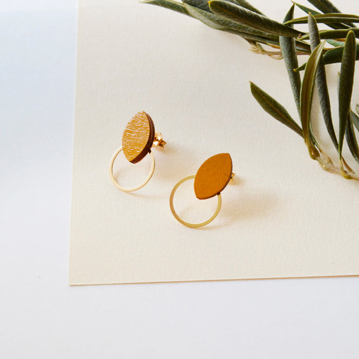 Pendientes de madera con forma de hoja de olivo en color mostaza y aro plano dorado en la parte inferior.