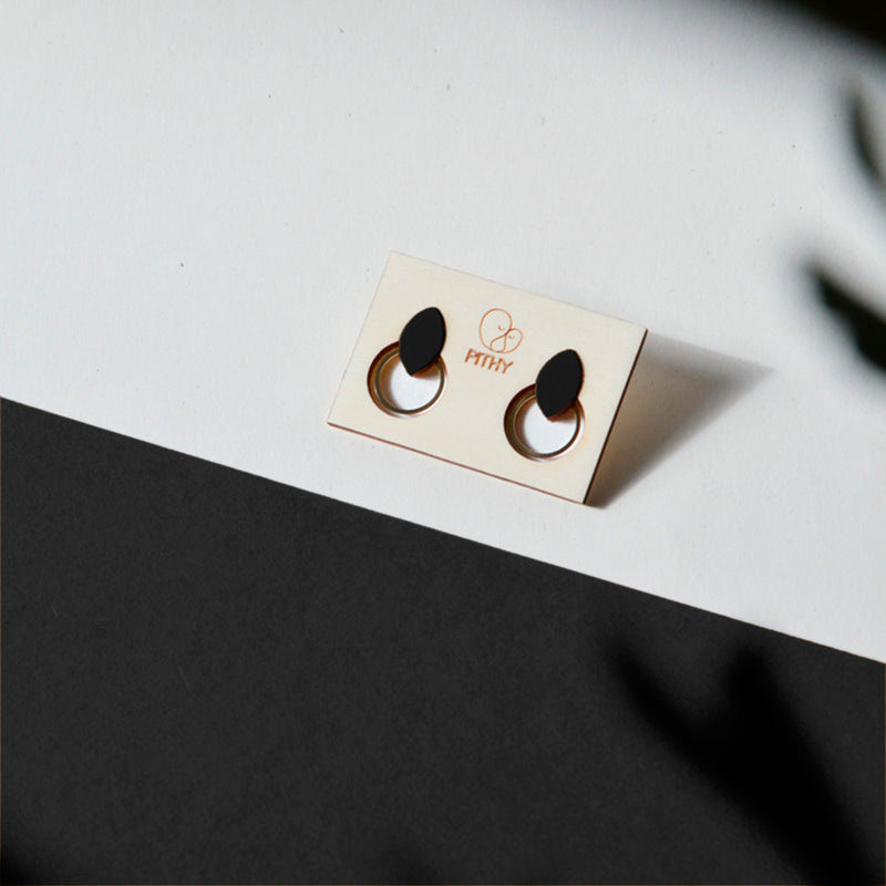 Pendientes de madera con forma de hoja de olivo en color negro y aro plano dorado en la parte inferior.