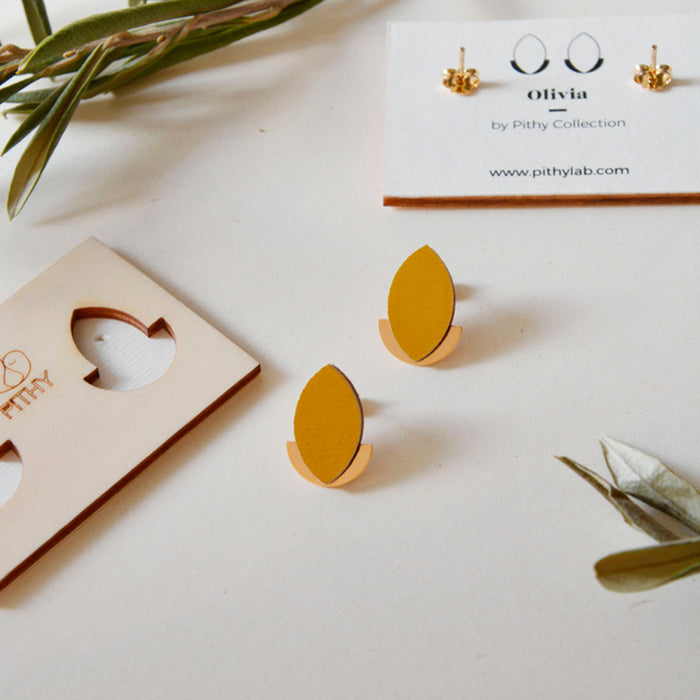 Pendientes de madera con forma de hoja de olivo en color mostaza y semicírculo dorado en la parte inferior trasera.