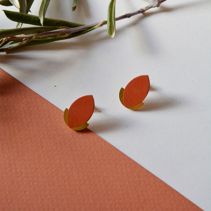 Pendientes de madera con forma de hoja de olivo en color terracota y semicírculo dorado en la parte inferior trasera.