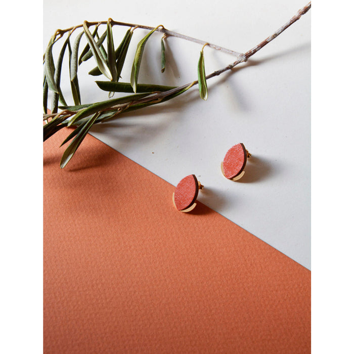 Pendientes de madera con forma de hoja de olivo en color terracota y semicírculo dorado en la parte inferior trasera.