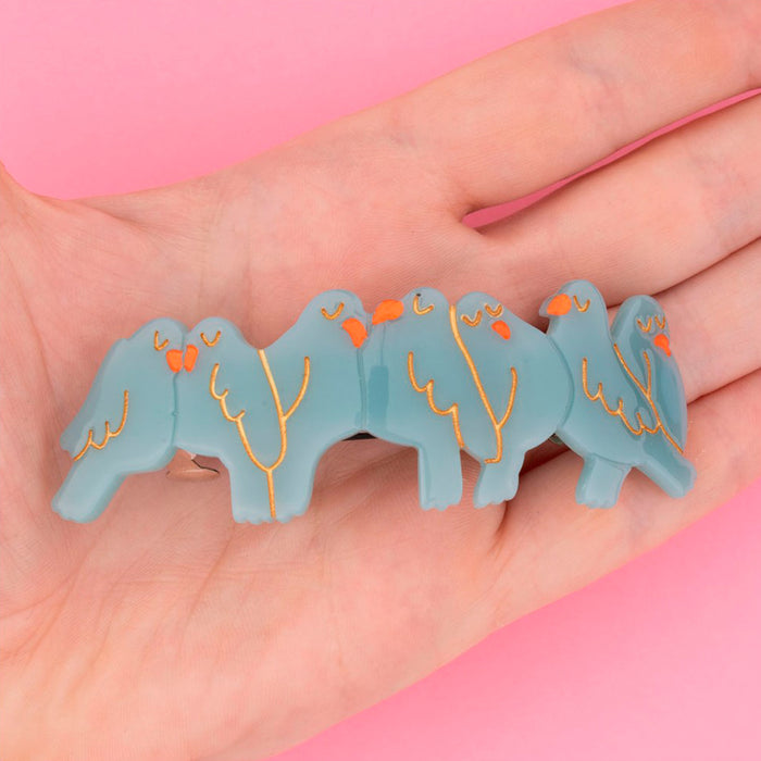 Pasador de pelo estilo barrette francés en forma de fila de pájaros azules con detalles dorados. Fabricado con acetato de celulosa reciclado.