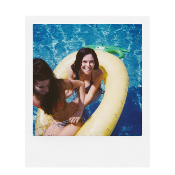 Fotografía polaroid 600 a color de dos mujeres en una piscina