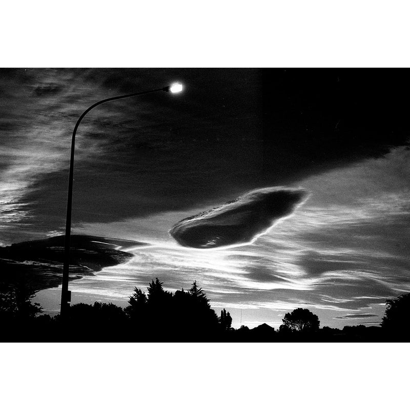 Fotografía en blanco y negro de farola y cielo nublado al anochecer tomada con la película Fomapan Profi Line Classic 100