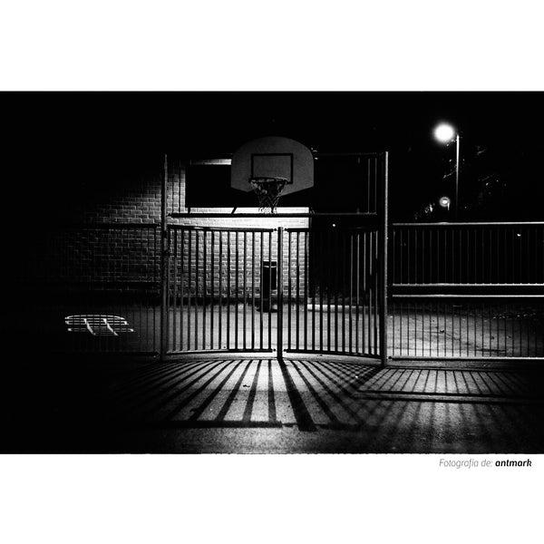 Fotografía en banco y negro tomada con la película Kodak  Trix  ISO  400  de una cancha de baloncesto en la noche