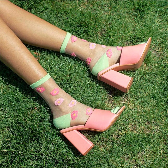 Calcetines de malla transparentes con dibujos de flores de cerezo rosa pálido y rosa. Calcetines con estampado de flores de cerezo con el remate, el talón y la punta en verde pistacho.