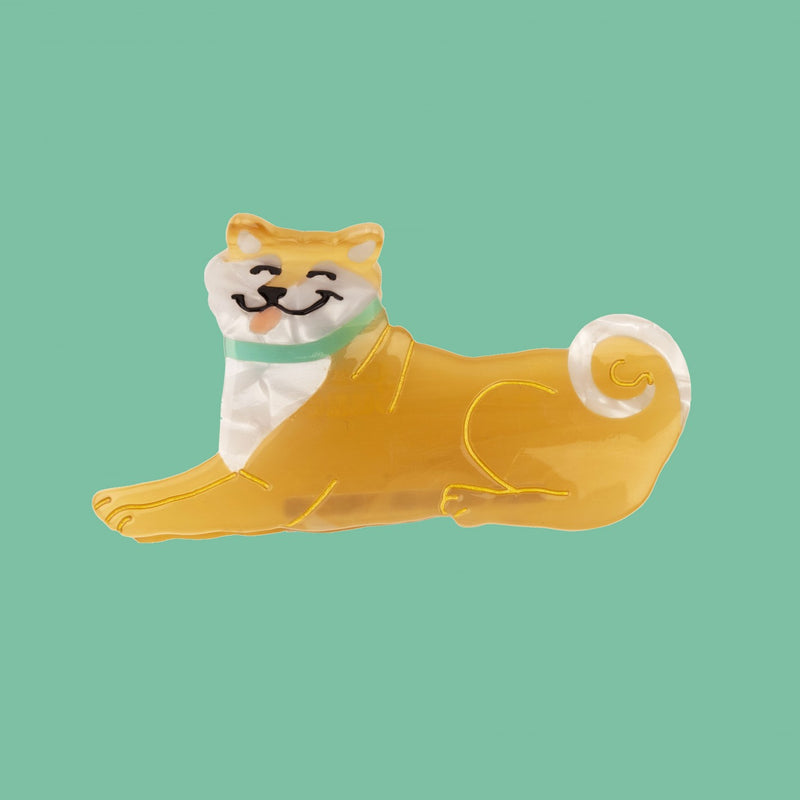 Pinza para el pelo en forma de perro shina inu/ aikita. Pinza divertida y original fabricada con acetato de celulosa reciclado y biodegradable. Visa sobre fondo verde.