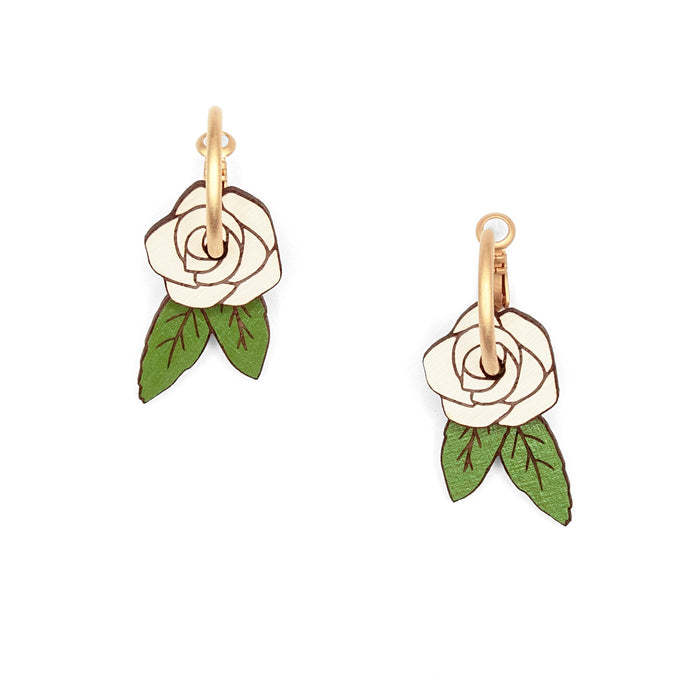 Pendientes de aro con charm de madera en forma de rosa blanca y hojas verdes.
