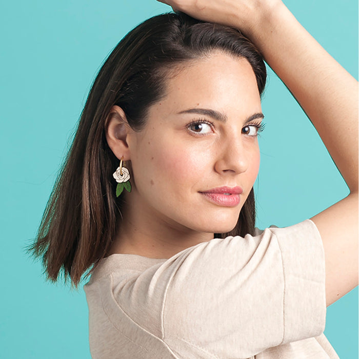 Pendientes de aro con charm de madera en forma de rosa blanca y hojas verdes.