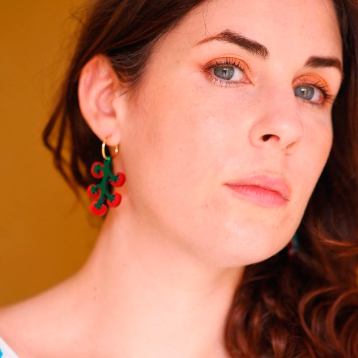 Modelo con Pendientes de metacrilato en forma de ramillete de tomates.