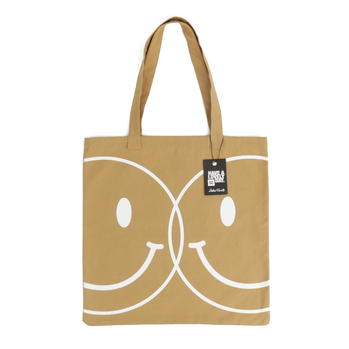 Tote bag color camel con serigrafía de dos caritas sonrientes tipo smiley en color blanco en una cara.