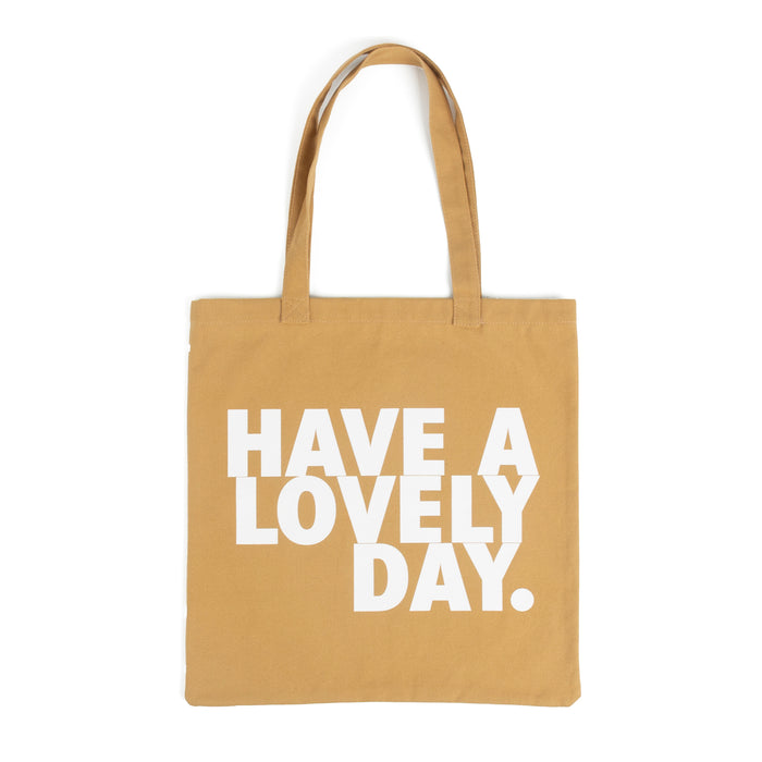 Tote bag color camel con serigrafía frase “Have a lovely day.” en mayúsculas en tipografía tipo sans serif en color blanco.
