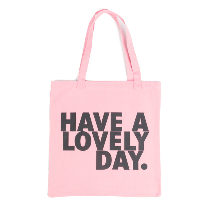 Tote bag color rosa con serigrafía frase “Have a lovely day.” en mayúsculas en tipografía tipo sans serif en color negro.