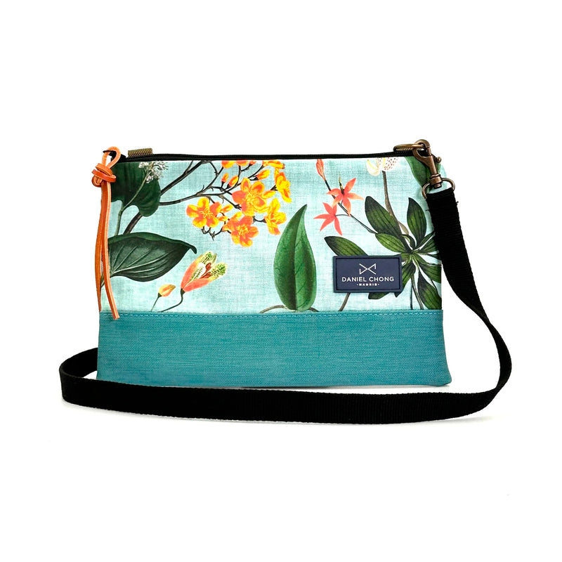Bandolera mini impermeable Daniel Chong - Flores con base turquesa