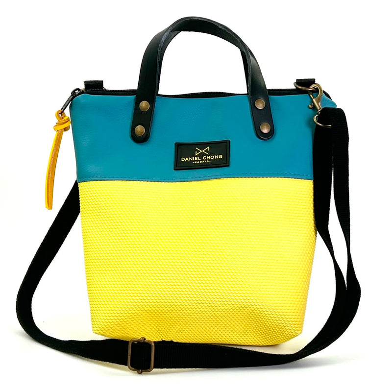 Bandolera mini impermeable con asas Daniel Chong - Asas negro cuerpo azul y amarillo
