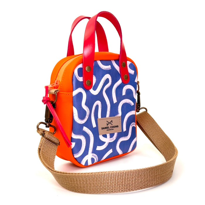 Bandolera Urban Box Mini con asas impermeable Daniel Chong - Vueltas y naranja