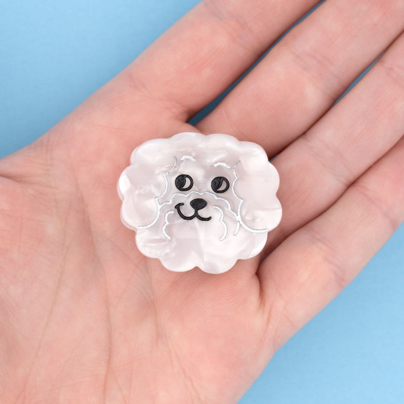 Divertida minipinza para el pelo en forma de bichon maltés. Un accesorio para el pelo en forma de perro bichón blanco, divertido y muy original. El complemento ideal para los que se atreven con todo. Perfecto para los amantes de los animales, de los perros y para los más coquetos.  Pinza pequeña fabricada con materiales reciclados: acetato de celulosa reciclada, por lo que es un complemento ecológico.