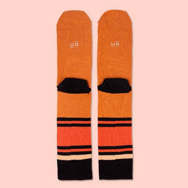 Parte trasera de calcetines divertidos de tonos anaranjados y rayas negras.