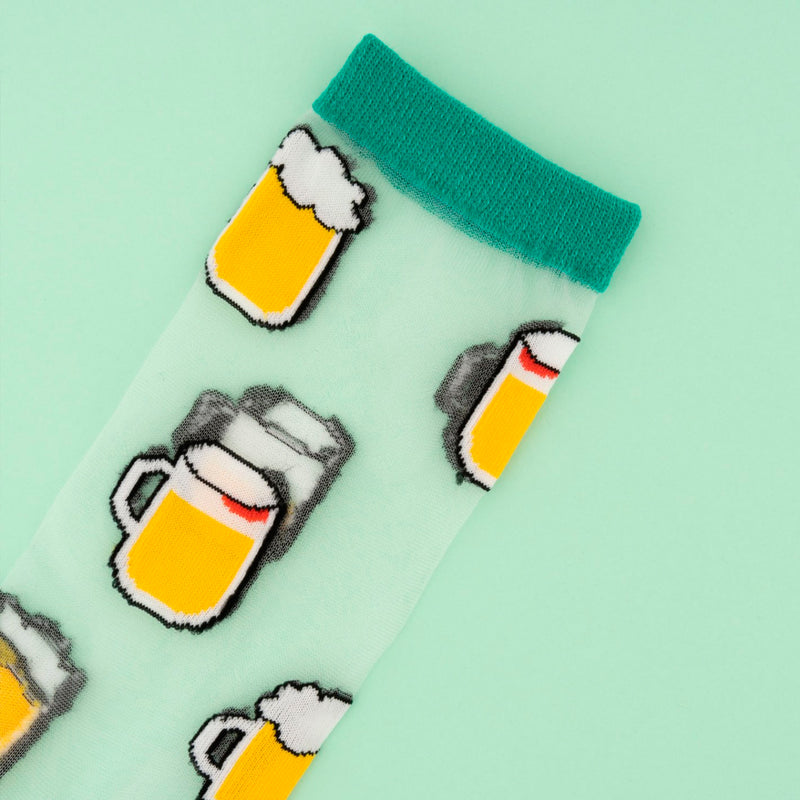 Calcetines de malla transparentes con dibujos de cervezas. Calcetines con estampado de jarras de cerveza con el remate, el talón y la punta en verde.