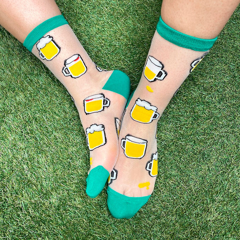 Calcetines de malla transparentes con dibujos de cervezas. Calcetines con estampado de jarras de cerveza con el remate, el talón y la punta en verde.
