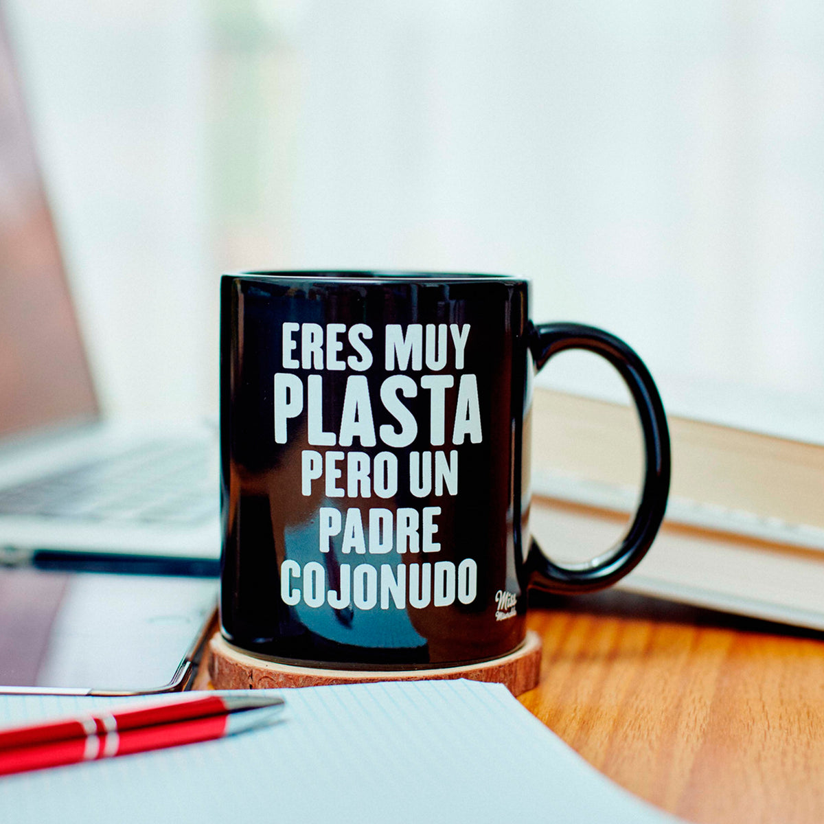 Taza de cerámica negra con frase "Eres muy plasta pero un padre cojonudo" en letras blancas. 