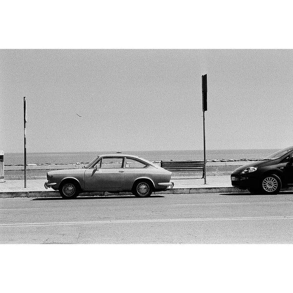 Fotografia en blanco y negro de coche vintage  aparcado frente a la playa tomada con la pelicula fomapan profi line action ISO 400  para camaras de 35mm