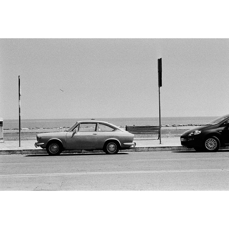 Fotografia en blanco y negro de coche vintage  aparcado frente a la playa tomada con la pelicula fomapan profi line action ISO 400  para camaras de 35mm
