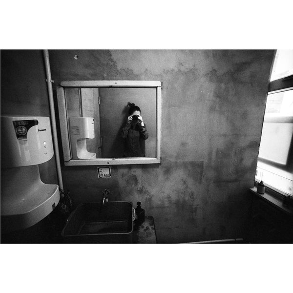 Autoretrato en blanco y negro tomado en espejo de un baño tomada con la película Fomapan Profi Line Action ISO 400 para cámaras de formato 120.