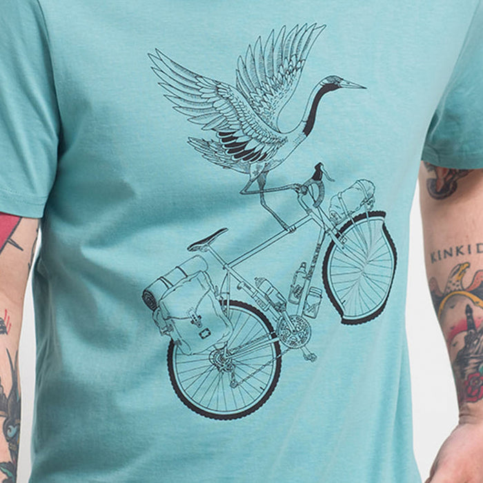 Camiseta azul claro con ilustración de grulla sobre una bicicleta con equipaje a línea negra. Camiseta de manga corta de talle medio impresa mediante serigrafía a una tinta. Camiseta ideal para los amantes de los viajes