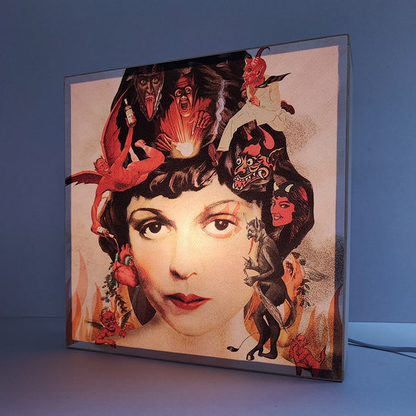 Caja de luz de madera y papel con la imagen de un rostro femenino rodeado de llamas y demonios. Caja de luz hecha de forma manual con imagen de rostro de mujer vintage, demonios y llamas.