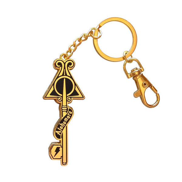 Llavero dorado metálico con forma de llave, la palabra "alohomora" y distintos elementos del universo Harry Potter. 