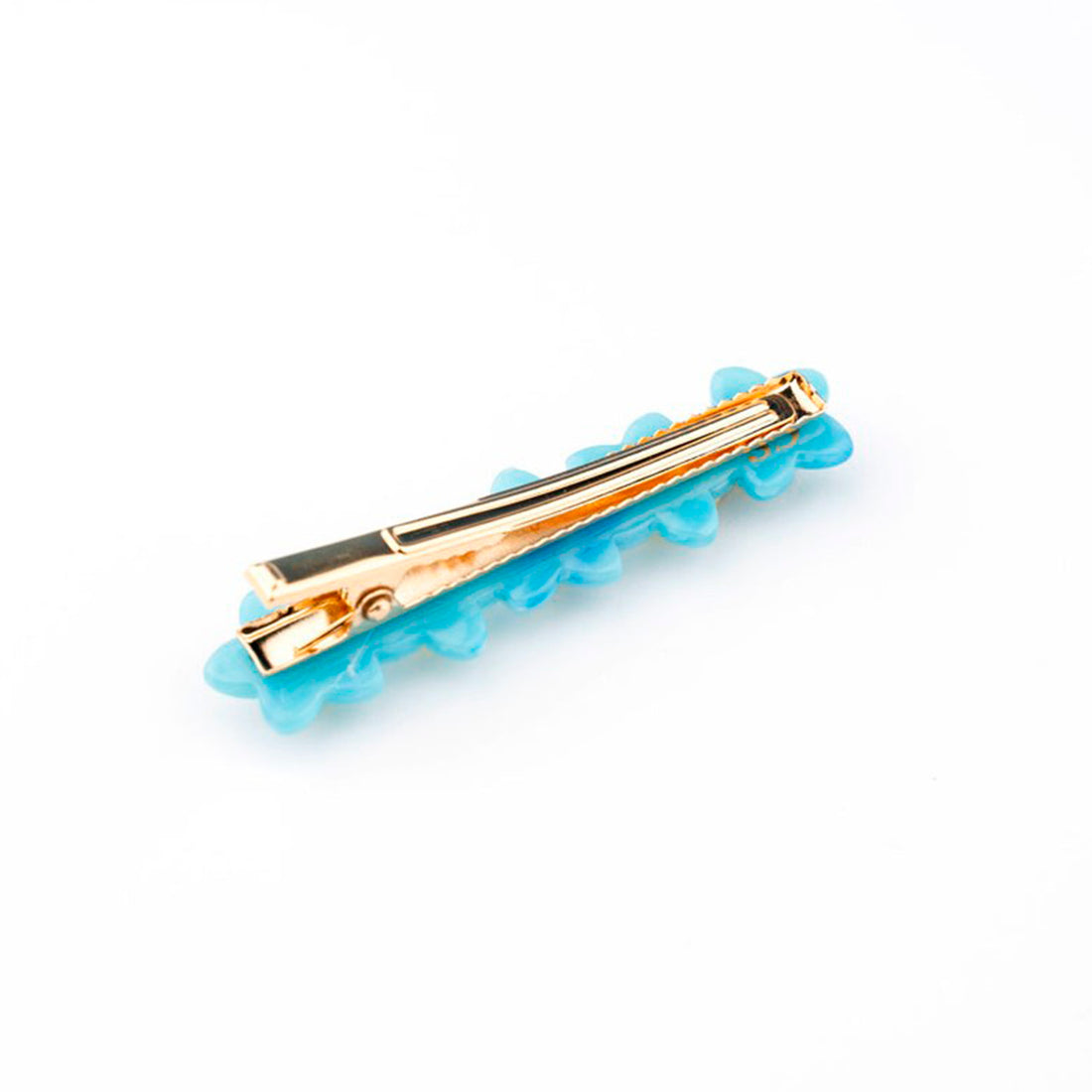 Pasador de pelo en forma de fila de flores nomeolvides azules con detalles en blanco y amarillo. Fabricado en acetato de celulosa reciclado. Vista trasera de la pinza.