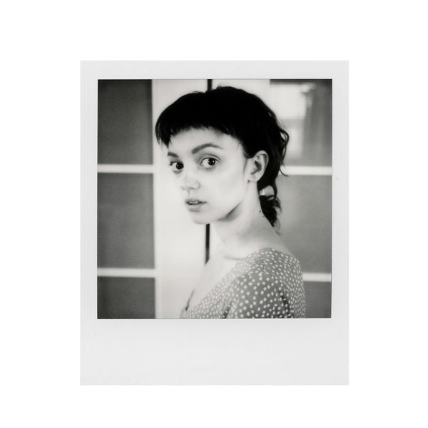 Fotografía Polaroid SX-70 en blanco y negro de primer plano de mujer blanca de pelo oscuro