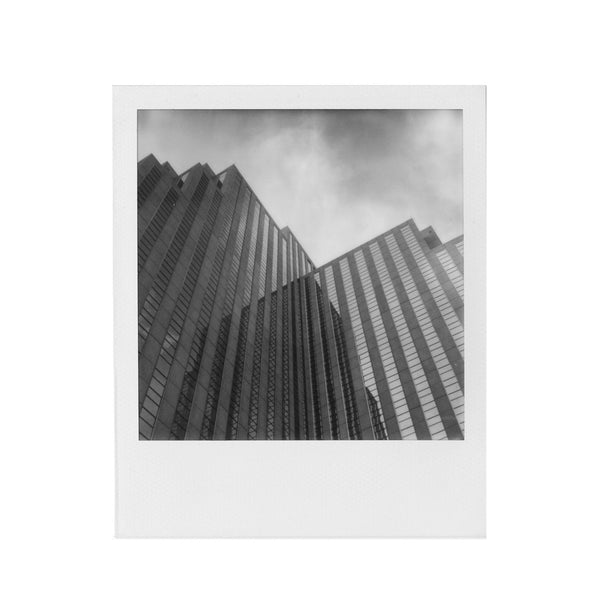 Fotografía Polaroid SX-70 en blanco y negro de picado de edificios con cristalera