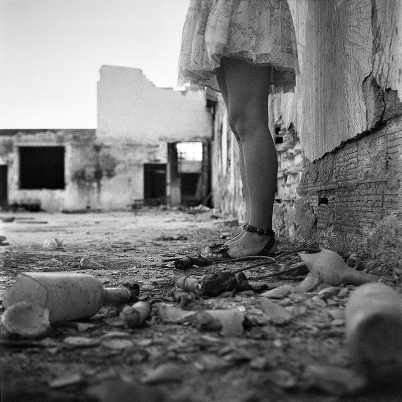 Fotografía en blanco y negro de piernas de mujer en zona en ruinas tomada con la película Fomapan Profi Line Classic ISO 100