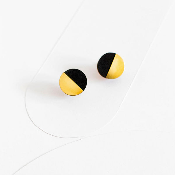 Pendientes de botón redondos, medio círculo de madera pintada de color negro y medio círculo de latón dorado.