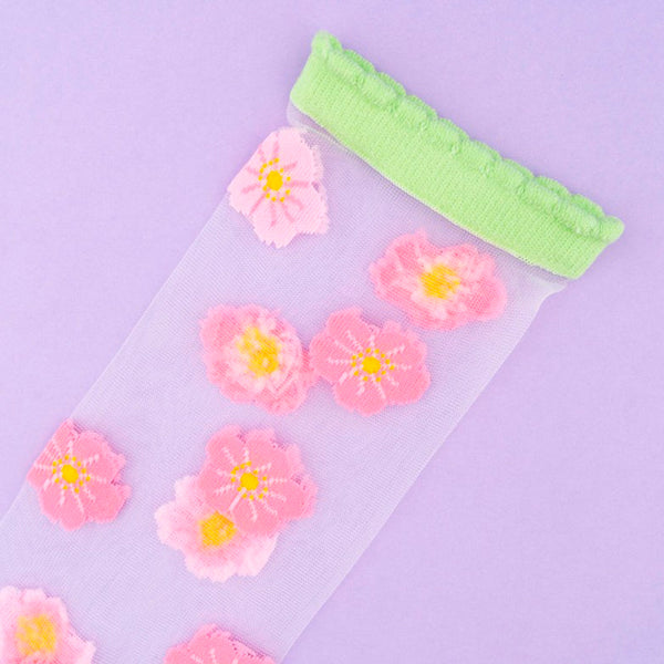 Calcetines de malla transparentes con dibujos de flores de cerezo rosa pálido y rosa. Calcetines con estampado de flores de cerezo con el remate, el talón y la punta en verde pistacho.