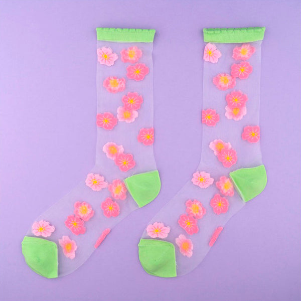 Calcetines de malla transparentes con dibujos de flores de cerezo rosa pálido y rosa. Calcetines con estampado de flores de cerezo con el remate, el talón y la punta en verde pistacho.