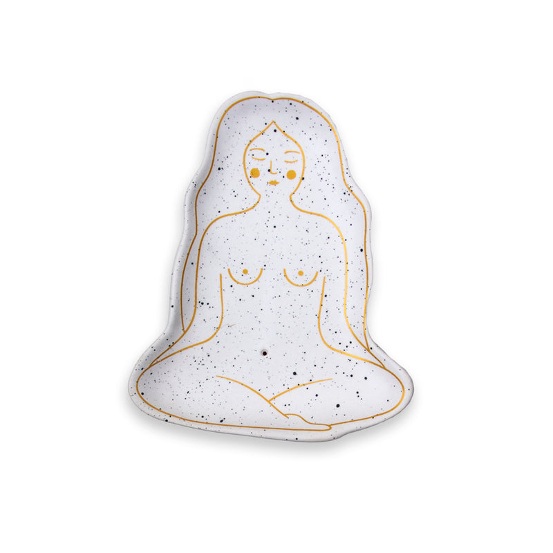 Bandeja para quemar barritas de incienso en forma de mujer meditando. Bandeja portainciensos de color blanco con motas negras y dibujo con líneas doradas.