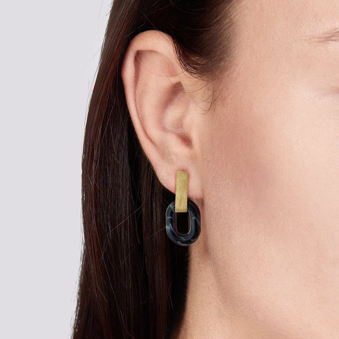 Pendientes elegantes y minimalistas compuestos por una pieza de latón rectangular vertical y un círculo negro de acetato con acabado mármol. Sofisticados pendientes geométricos ideales tanto para looks de diario como de fiesta.