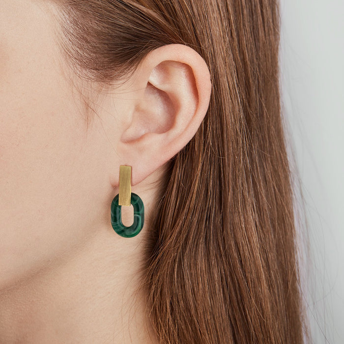 Pendientes elegantes y minimalistas compuestos por una pieza de latón rectangular vertical y un círculo verde de acetato con acabado mármol. 